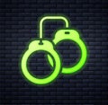 Glowing neon Handcuffs icon isolated on brick wall background. Vector