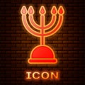 Glowing neon Hanukkah menorah icon isolated on brick wall background. Hanukkah traditional symbol. Holiday religion