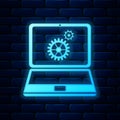 Glowing neon Laptop and gears icon isolated on brick wall background. Laptop service concept. Adjusting app, setting Royalty Free Stock Photo