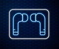 Glowing neon line Air headphones icon icon isolated on brick wall background. Holder wireless in case earphones Royalty Free Stock Photo