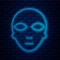 Glowing neon line Alien icon isolated on brick wall background. Extraterrestrial alien face or head symbol. Vector