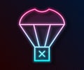 Glowing neon line Box flying on parachute icon isolated on black background. Parcel with parachute for shipping Royalty Free Stock Photo