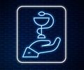 Glowing neon line Caduceus snake medical symbol icon isolated on brick wall background. Medicine and health care. Emblem