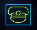 Glowing neon line Captain hat icon isolated on brick wall background. Vector