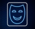 Glowing neon line Comedy theatrical mask icon isolated on brick wall background. Vector