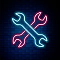 Glowing neon line Crossed wrenchs icon isolated on brick wall background. Spanner repair tool. Service tool symbol