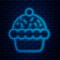 Glowing neon line Cupcake icon isolated on brick wall background. Vector