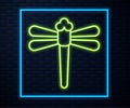 Glowing neon line Dragonfly icon isolated on brick wall background. Vector