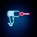 Glowing neon line Drill machine icon isolated on brick wall background. Colorful outline concept. Vector