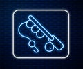 Glowing neon line Fishing rod icon isolated on brick wall background. Fishing equipment and fish farming topics. Vector