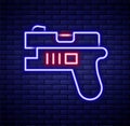 Glowing neon line Futuristic space gun blaster icon isolated on brick wall background. Laser Handgun. Alien Weapon