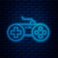 Glowing neon line Gamepad icon isolated on brick wall background. Game controller. Vector