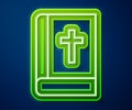 Glowing neon line Holy bible book icon isolated on blue background. Vector