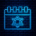 Glowing neon line Jewish calendar with star of david icon isolated on brick wall background. Hanukkah calendar day