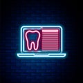 Glowing neon line Laptop with dental card or patient medical records icon isolated on brick wall background. Dental