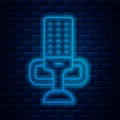 Glowing neon line Microphone icon isolated on brick wall background. On air radio mic microphone. Speaker sign. Vector Royalty Free Stock Photo