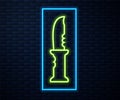 Glowing neon line Military knife icon isolated on brick wall background. Vector