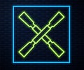 Glowing neon line Oars or paddles boat icon isolated on brick wall background. Vector