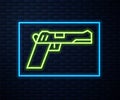 Glowing neon line Pistol or gun icon isolated on brick wall background. Police or military handgun. Small firearm