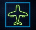 Glowing neon line Plane icon isolated on brick wall background. Flying airplane icon. Airliner sign. Vector Royalty Free Stock Photo