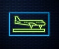 Glowing neon line Plane icon isolated on brick wall background. Flying airplane icon. Airliner sign. Vector Royalty Free Stock Photo