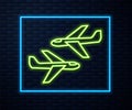 Glowing neon line Plane icon isolated on brick wall background. Flying airplane icon. Airliner sign. Vector Royalty Free Stock Photo