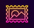 Glowing neon line Postal stamp icon isolated on black background. Vector Illustration