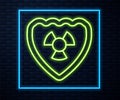 Glowing neon line Radioactive in shield icon isolated on brick wall background. Radioactive toxic symbol. Radiation