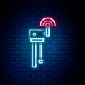 Glowing neon line Router and wi-fi signal symbol icon isolated on brick wall background. Wireless ethernet modem router