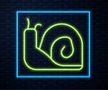 Glowing neon line Snail icon isolated on brick wall background. Vector