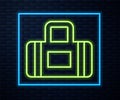 Glowing neon line Sport bag icon isolated on brick wall background. Vector