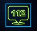 Glowing neon line Telephone with emergency call 112 icon isolated on brick wall background. Police, ambulance, fire