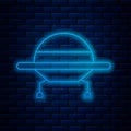 Glowing neon line UFO flying spaceship icon isolated on brick wall background. Flying saucer. Alien space ship Royalty Free Stock Photo