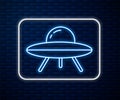 Glowing neon line UFO flying spaceship icon isolated on brick wall background. Flying saucer. Alien space ship Royalty Free Stock Photo