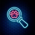 Glowing neon line Veterinary clinic symbol icon isolated on brick wall background. Cross hospital sign. Stylized paw