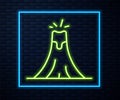 Glowing neon line Volcano eruption with lava icon isolated on brick wall background. Vector