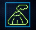 Glowing neon line Volcano icon isolated on brick wall background. Vector