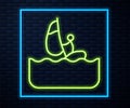 Glowing neon line Windsurfing icon isolated on brick wall background. Vector