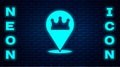 Glowing neon Location king crown icon isolated on brick wall background. Vector