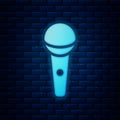 Glowing neon Microphone icon isolated on brick wall background. On air radio mic microphone. Speaker sign. Vector Royalty Free Stock Photo
