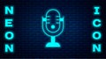 Glowing neon Microphone icon isolated on brick wall background. On air radio mic microphone. Speaker sign. Vector