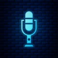 Glowing neon Microphone icon isolated on brick wall background. On air radio mic microphone. Speaker sign. Vector Royalty Free Stock Photo