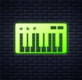 Glowing neon Music synthesizer icon isolated on brick wall background. Electronic piano. Vector Royalty Free Stock Photo