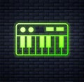 Glowing neon Music synthesizer icon isolated on brick wall background. Electronic piano. Vector Royalty Free Stock Photo