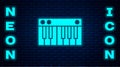 Glowing neon Music synthesizer icon isolated on brick wall background. Electronic piano. Vector Illustration Royalty Free Stock Photo