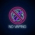 Glowing neon no vaping sign on dark brick wall background. Vape free area symbol. Signboard of no smoking place