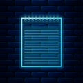 Glowing neon Notebook icon isolated on brick wall background. Spiral notepad icon. School notebook. Writing pad. Diary