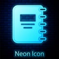 Glowing neon Notebook icon isolated on brick wall background. Spiral notepad icon. School notebook. Writing pad. Diary