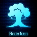 Glowing neon Nuclear explosion icon isolated on brick wall background. Atomic bomb. Symbol of nuclear war, end of world