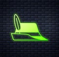 Glowing neon Oktoberfest hat icon isolated on brick wall background. Hunter hat with feather. German hat. Vector